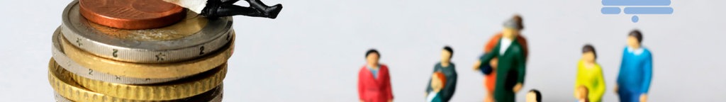 Ein Figürchen liegt auf einem Geldstapel, während andere Figuren auf kleineren Geldstapeln zu ihm hoch schauen