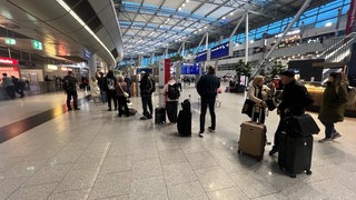 Fluggäste stehen in der Eingangshalle des Flughafen Düsseldorf