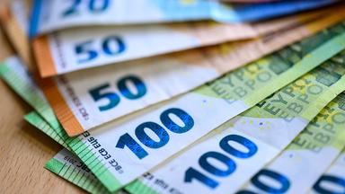 Geldscheine liegen auf einem Tisch.